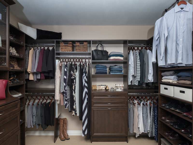 Custom walk-in closet with dark espresso surround system and full hanging storage